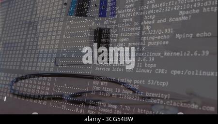 Displaying Nmap port scan overlay on screen at workstation, with laptop keyboard and network cable Stock Photo