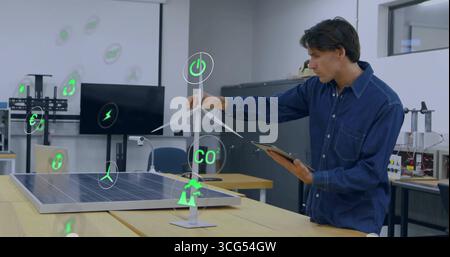 Denim-shirted engineer adjusting turbine in lab, with solar panel, tablet, energy icons, copy space Stock Photo