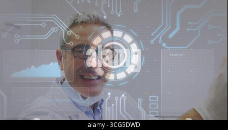 Smiling technician wearing lab coat or eyeglasses using HUD overlay in lab, with computer monitor Stock Photo