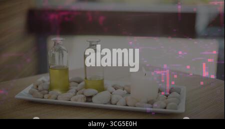 Displaying tray holding pebbles, glass bottles with golden oil, candle on woven mat in spa room Stock Photo
