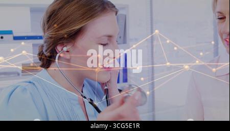 Placing stethoscope earpieces, scrub-clad trainee adjusting earpieces in clinic office, copy space Stock Photo