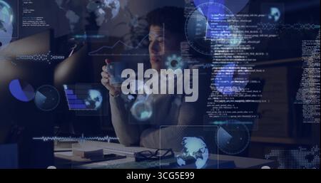 Analyzing code man wearing sweater sipping coffee at monitor in home office with HUD overlays Stock Photo