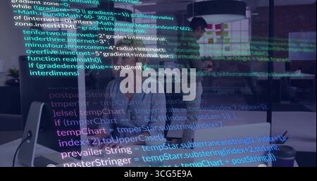 Typing code middle-aged female developer in blouse at office with desktop monitor and code overlay Stock Photo