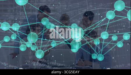 Collaborating corporate team reviewing documents and laptops at conference table, with data overlay Stock Photo