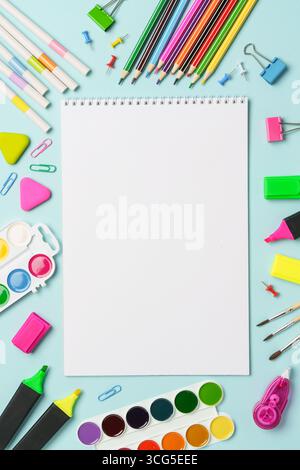 Sketch book, markers, watercolor paints and pencils on blue background. Art creative composition with space for text. Stock Photo