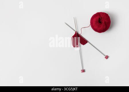 Vinous knitted wool on gray background with knitting needles for knitting warm clothes and hobbies needlework Stock Photo