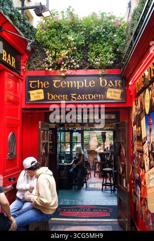 Exterior view of The Temple Bar, a famous pub in Dublin, Ireland, with its iconic red facade and beer garden. Stock Photo