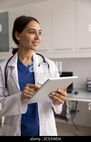 Happy young Middle Eastern physician woman using digital tablet Stock Photo