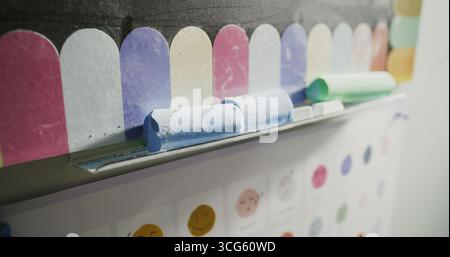 Close Up of Colorful Chalks for Drawing or Writing Lying on Blackboard in Modern Primary School Classroom. Creative Space for Children Studying and Education, Development of Imagination, Creativity. Stock Photo