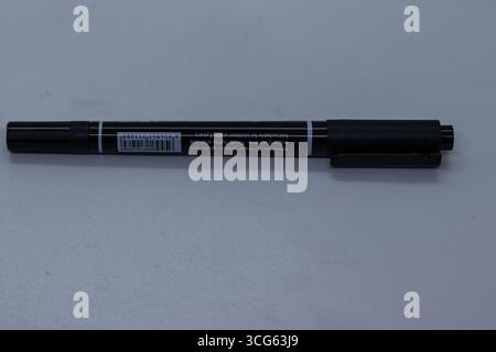 Close-up image of a sleek black ink ball pen resting on a wooden desk. Ideal for office, writing, stationery, business. Stock Photo