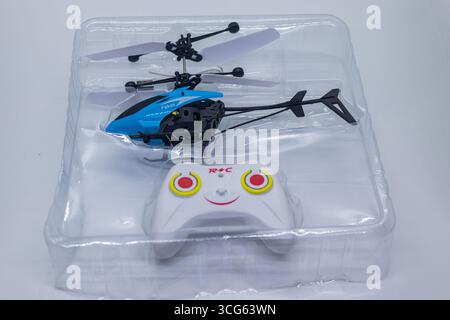 Bright Blue Remote Controlled Toy Helicopter in Clear Plastic Packaging on White Background. Stock Photo