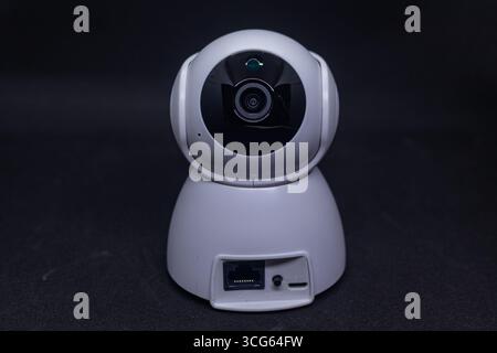 Close-up of a CCTV dome camera featuring a transparent glass cover on an isolated white background. Modern security device designed for surveillance. Stock Photo