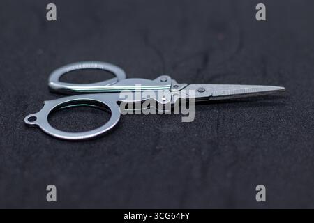 Close-up of children’s craft scissors featuring bright yellow plastic handles and pointed stainless steel blades. Safe. Stock Photo
