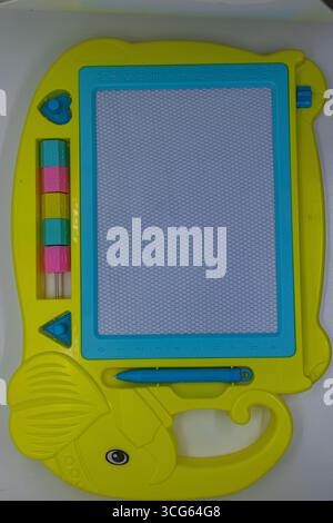 Children’s magnetic drawing board featuring a colorful abacus and stylus on a clean white background. Educational toy promoting creativity, learning, Stock Photo
