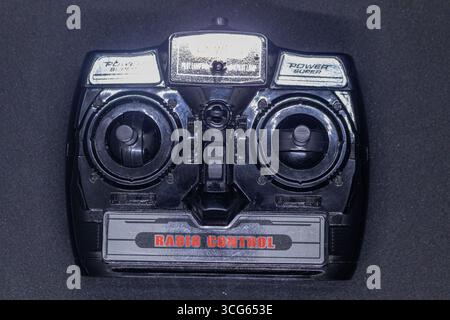Close-up of a classic radio control device, ideal for operating remote vehicles. Vintage-style controller with ergonomic design, buttons, and antenna. Stock Photo