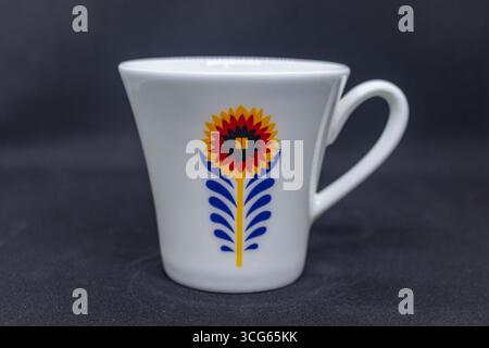 Colorful porcelain cup featuring a vibrant sunflower design, perfect for tea or coffee. Decorative and elegant ceramic drinkware ideal for kitchens, d Stock Photo