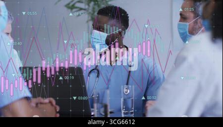 Medical team in scrubs analyzing candlestick chart in hospital room, with laptop and stethoscopes Stock Photo
