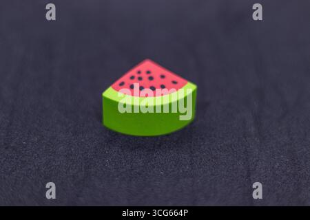 Colorful watermelon slice eraser designed for kids, placed on a black background. Fun and vibrant stationery item perfect for school, art projects, an Stock Photo