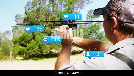 Adjusting man in baseball cap tuning black drone amid trees with social media icons, copy space Stock Photo
