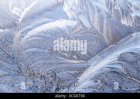 Intricate frost patterns detailed on a window during a cold winter morning Stock Photo