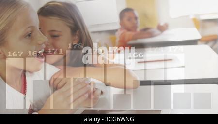 Leaning two girls whispering at school desk in classroom, with pencil paper bar charts, copy space Stock Photo