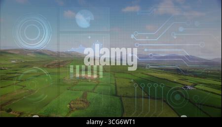 Displaying holographic overlay over rural valley farmland showing circular graphs and bar charts Stock Photo