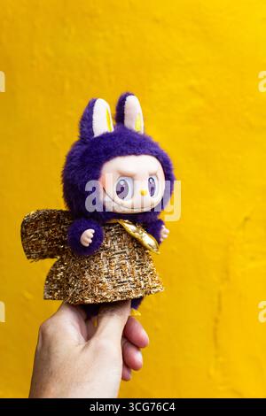 Purple colour Labubu in gold shiny dress posing on a gate grill design on street at Little India, Singapore Stock Photo - Alamy Purple colour Labubu in gold shiny dress posing on a gate grill design on street at Little India, Singapore Stock Photo - Alamy