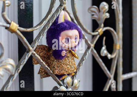 Purple colour Labubu in gold shiny dress posing on a gate grill design on street at Little India, Singapore Stock Photo - Alamy Purple colour Labubu in gold shiny dress posing on a gate grill design on street at Little India, Singapore Stock Photo - Alamy