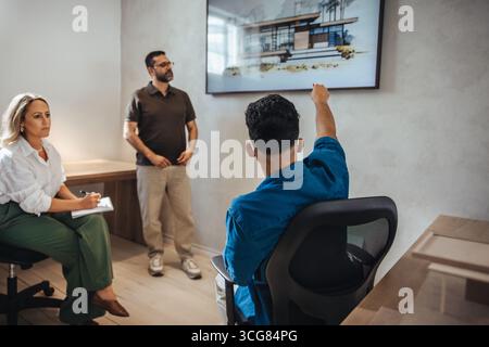 A group of architects collaborating on a project, analyzing a modern building design. The atmosphere conveys a sense of creativity, teamwork, and prof Stock Photo