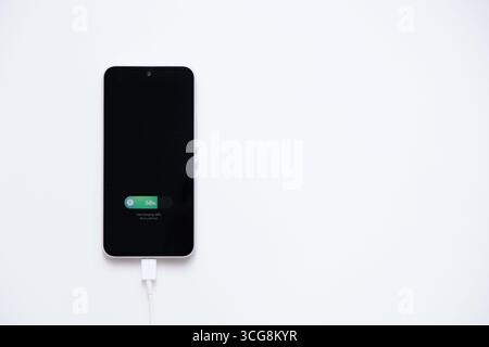 Charging mobile phone battery with fast charging mode, isolated on white background Stock Photo