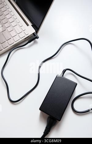 Charging laptop with power adapter isolated on white background Stock Photo