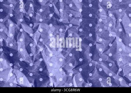 Color of the year 2022 very peri. Crumpled paper woth drops for gift wrapping or packaging. Close up texture background Stock Photo