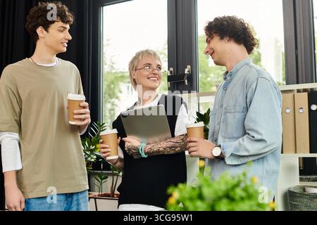 Three energetic young individuals share ideas and enjoy coffee in a vibrant workspace. Stock Photo