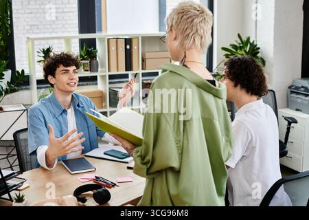 Dynamic interaction between young professionals discussing ideas at a stylish office workspace. Stock Photo