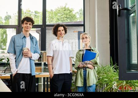 Three young people are collaborating in a bright office. Stock Photo