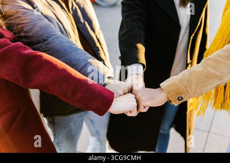Close up group of young students stacking hands together Stock Photo