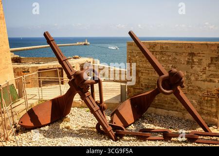Rusted anchor chain in deep blue ocean connecting surface vessel to ...