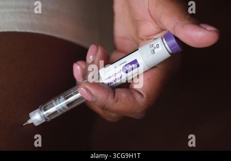 A person uses a 5mg pre-filled injection pen of Mounjaro, the tirzepatide  weight loss medication manufactured by US manufacturer Eli Lilly, who have  announced the price of the jab is rising by