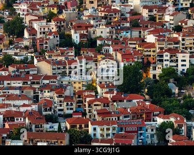 Thessaloniki, Greece 3 August 2025. Aerial drone view of colorful traditional neighborhood with red tile roofs, mixed architecture and green trees Stock Photo