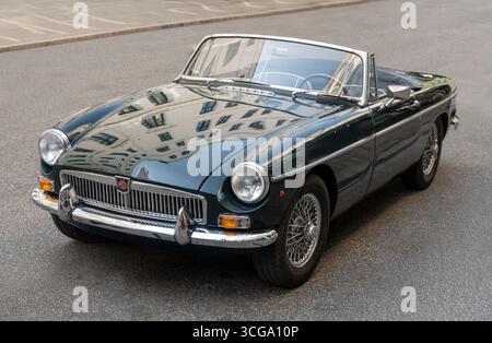 Racing green 1967 MGB convertible sports car with reflections of buildings , Copenhagen, Denmark - August 14, 2025. Stock Photo