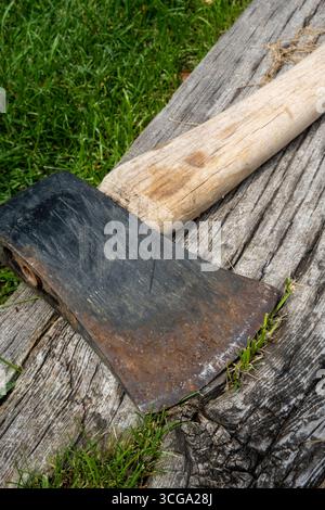 Close-up of a vintage axe with a wooden handle on a backyard railroad tie, Montana, 2025, USA Stock Photo