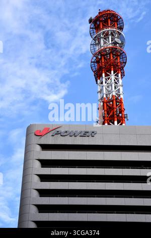 J-POWER head office building in Ginza, Tokyo, featuring a prominent red and white telecommunications tower on its roof - Japan Stock Photo