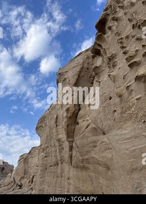 Unique natural rock formations shaped by erosion against a backdrop of scattered clouds in southern Iran. Stock Photo