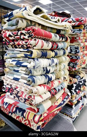 Stack of colorful blankets are on display. The blankets are in different colors and patterns. There are many blankets on display, and they are all sta Stock Photo