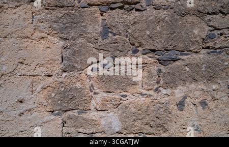 Rustic ancient stone wall surface with irregular blocks, perfect texture for backgrounds and design Stock Photo