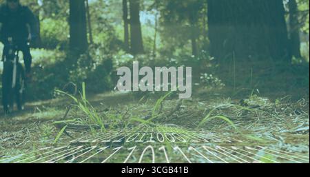 Riding cyclist wearing helmet, sunglasses, pedaling bike on pine trail with binary map, copy space Stock Photo