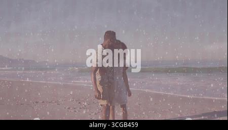 Planting soft forehead kiss couple standing at sandy shore, sunglasses and textured overlay Stock Photo