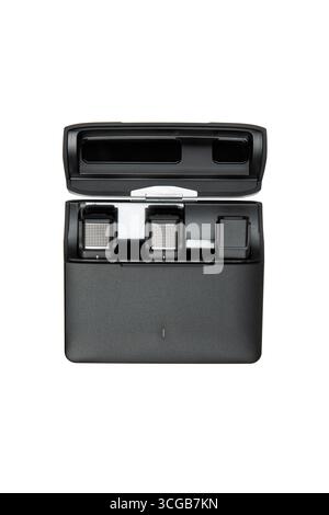 An open black charging case holds two small microphones and an adapter. Stock Photo