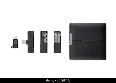 A set of black microphones and a charging case on a white background. Stock Photo