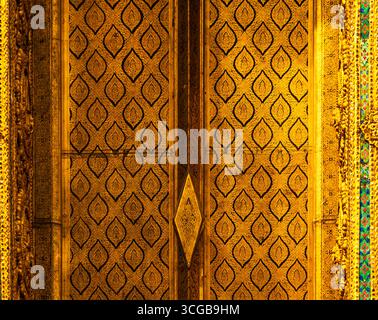 Intricate golden patterned door with diamond shapes and floral motifs in the royal palace of Bangkok Stock Photo
